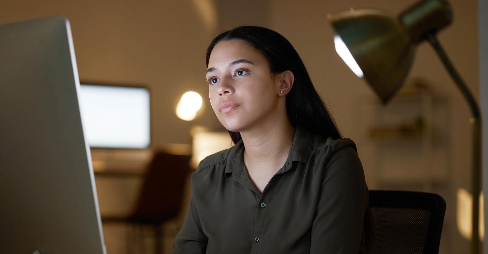 Woman working on laptop at her desk.