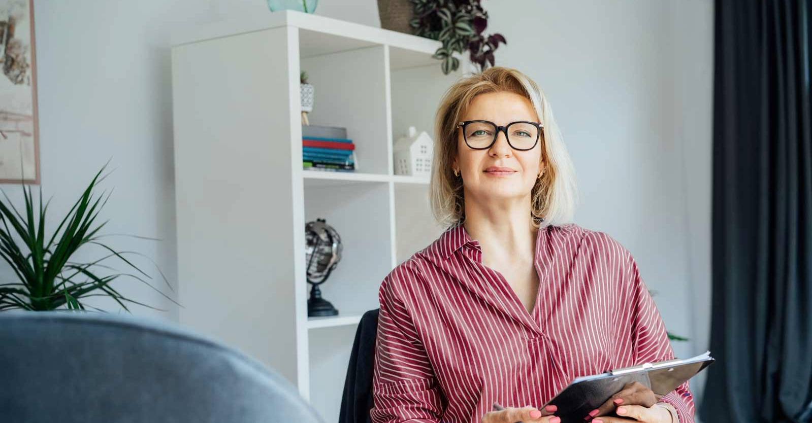A woman psychologist smiles at the camera.