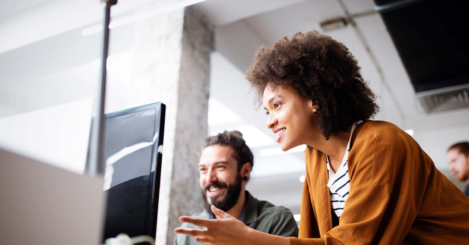 Woman showing someone something on a computer screen
