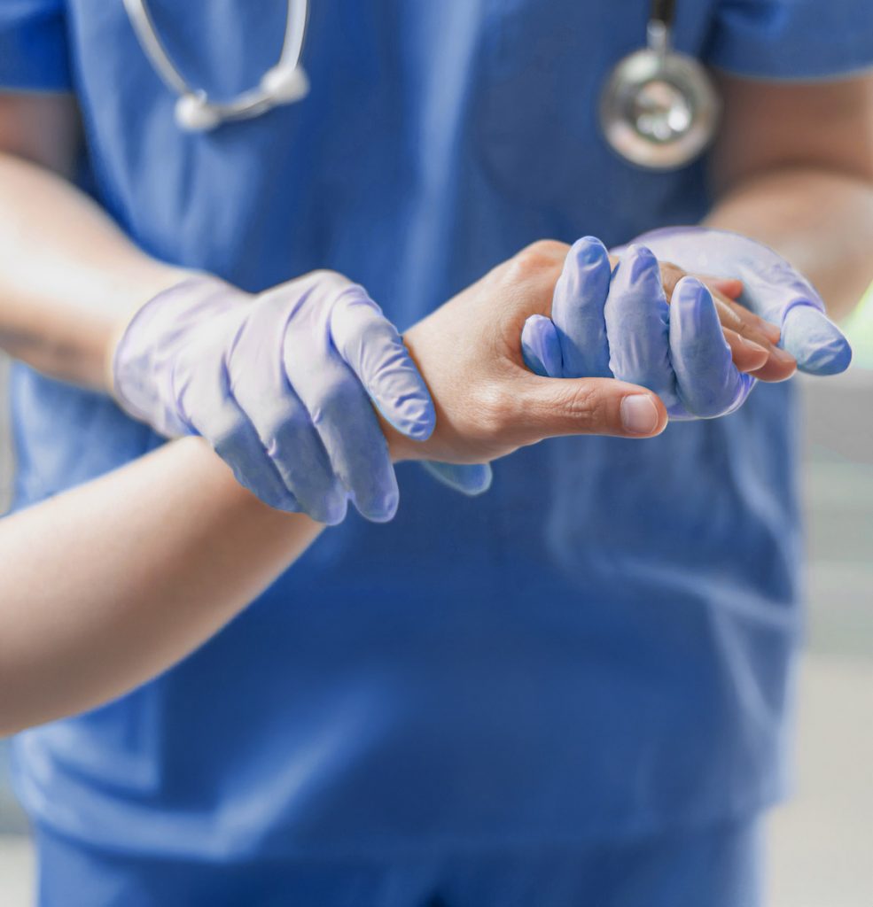 Nurse holding patient's hand for health care trust and support in surgical procedure