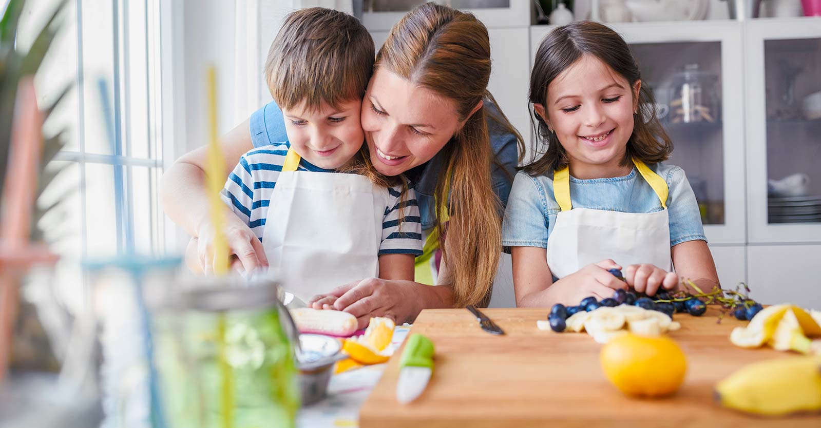 Person helping children prepare fruit for a meal.