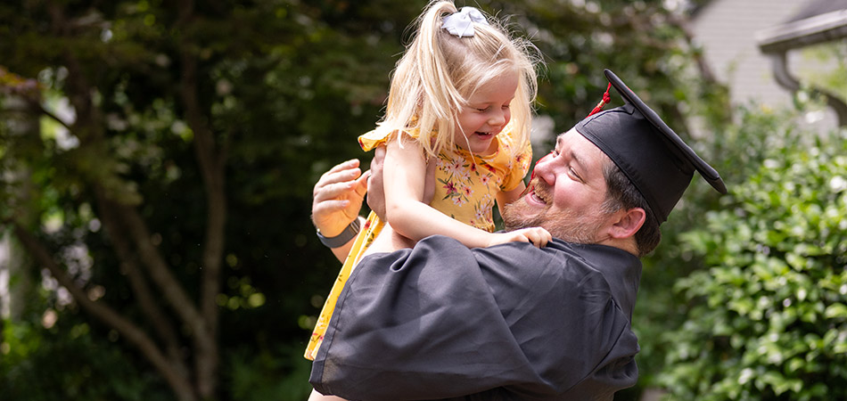 Graduating father holding his daughter