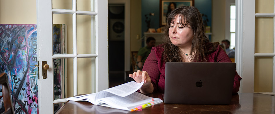 Student sitting at a table reading a textbook